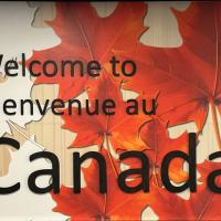 Welcome to Canada billboard with red and orange maple leaves